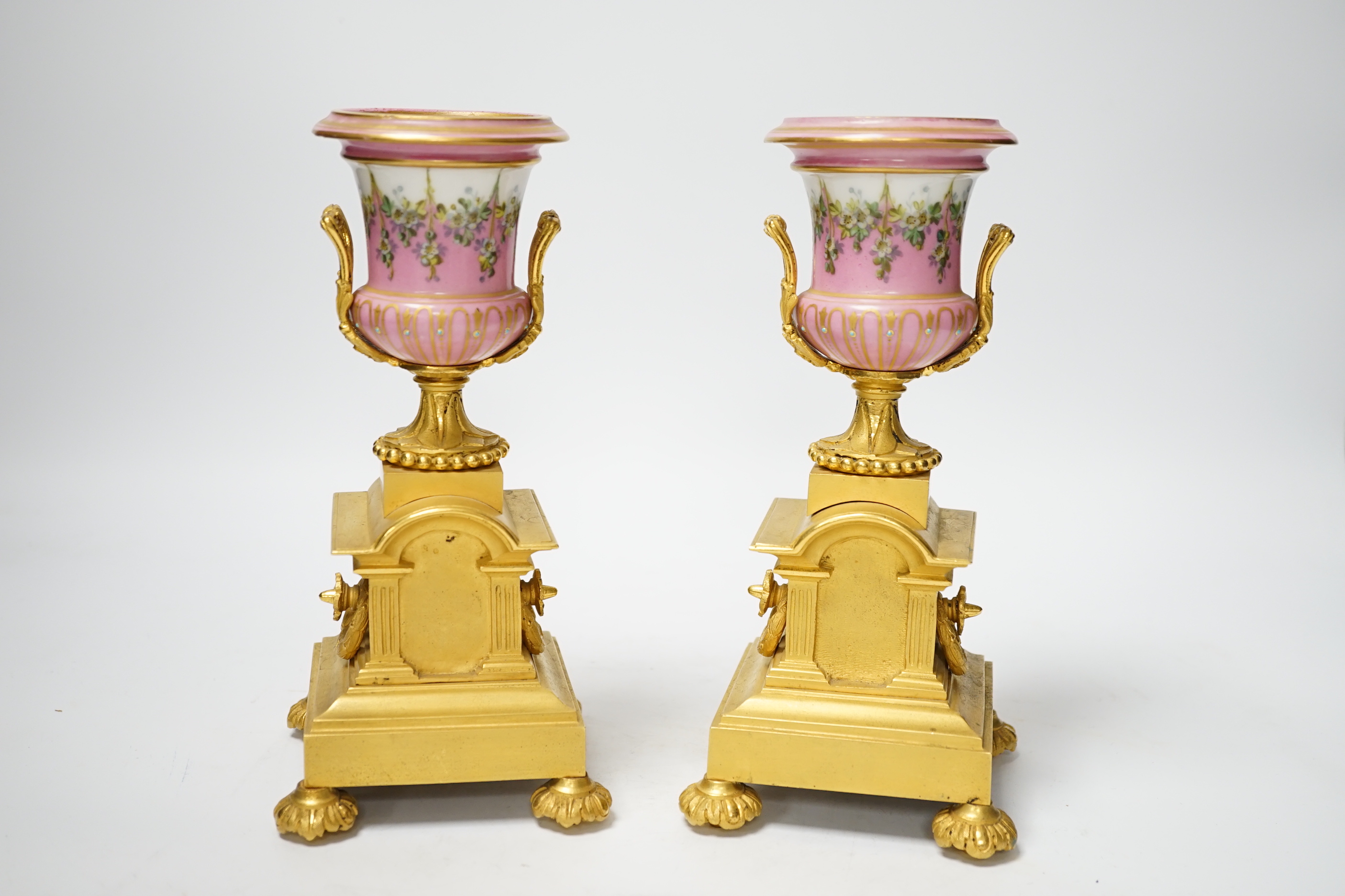 A pair of late 19th century French ormolu and pink floral porcelain urns, 20.5cm high